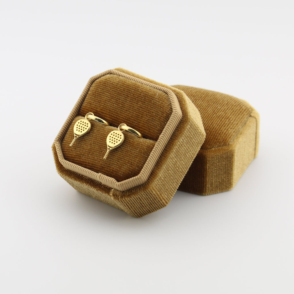 Padel drop huggie earrings in a brown velvet box on a white background