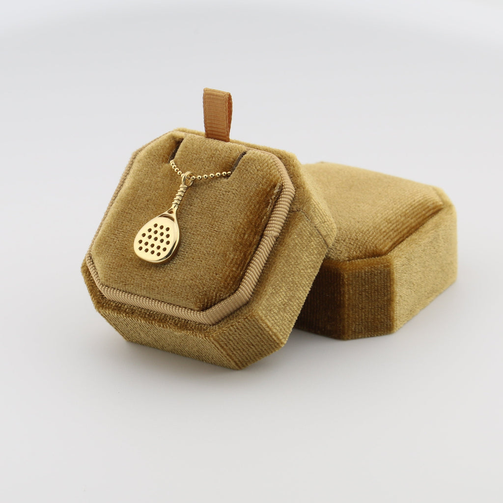 Gold padel necklace for men in a decorative brown box on a white background