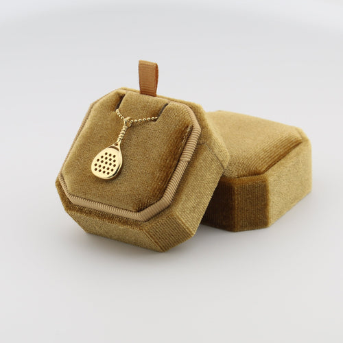 Gold padel necklace for men in a decorative brown box on a white background